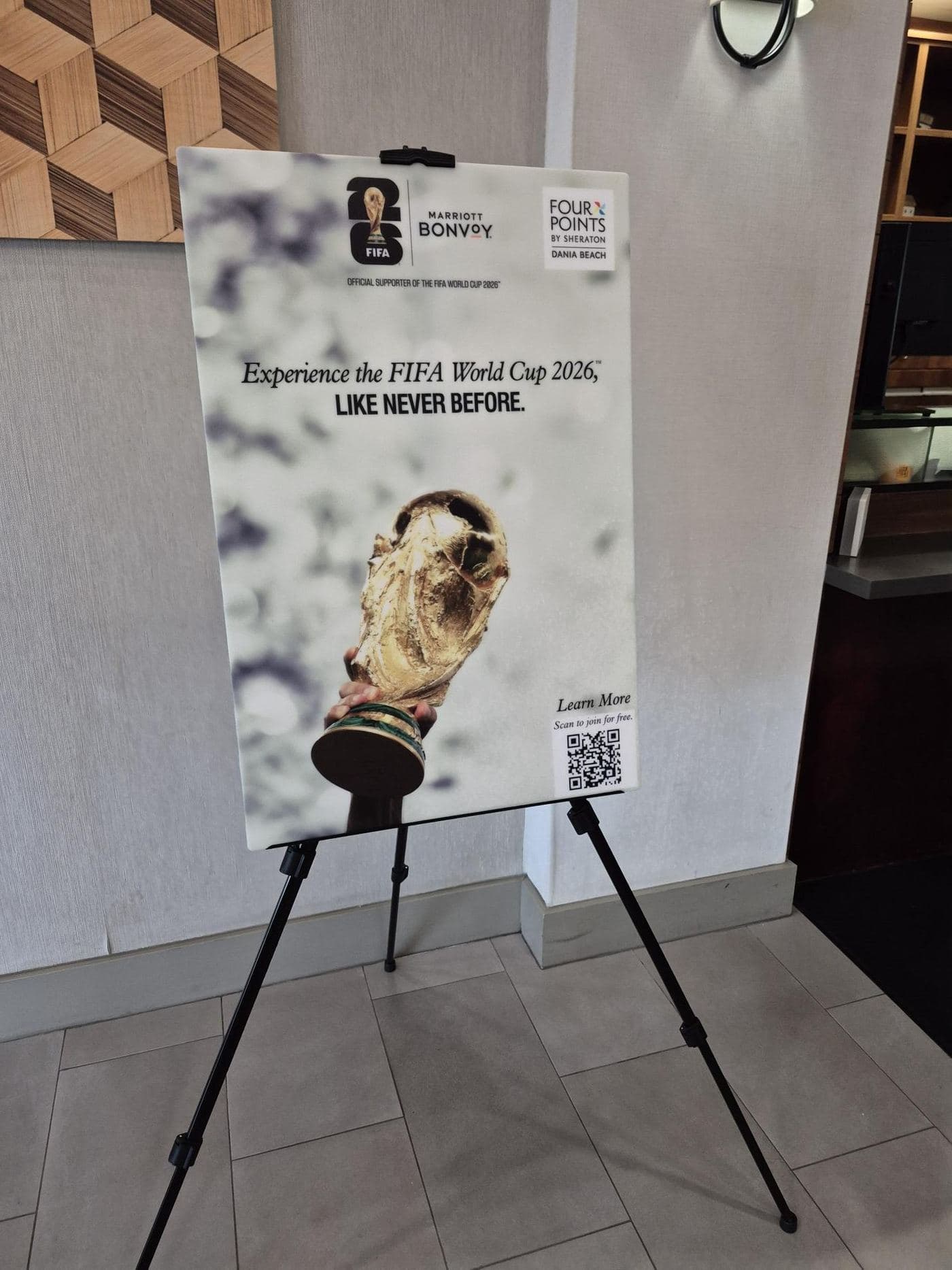 A printed rigid panel sign standing on a folding easel in a Tampa hotel lobby, the same setup we use for memorial welcome boards at receptions.