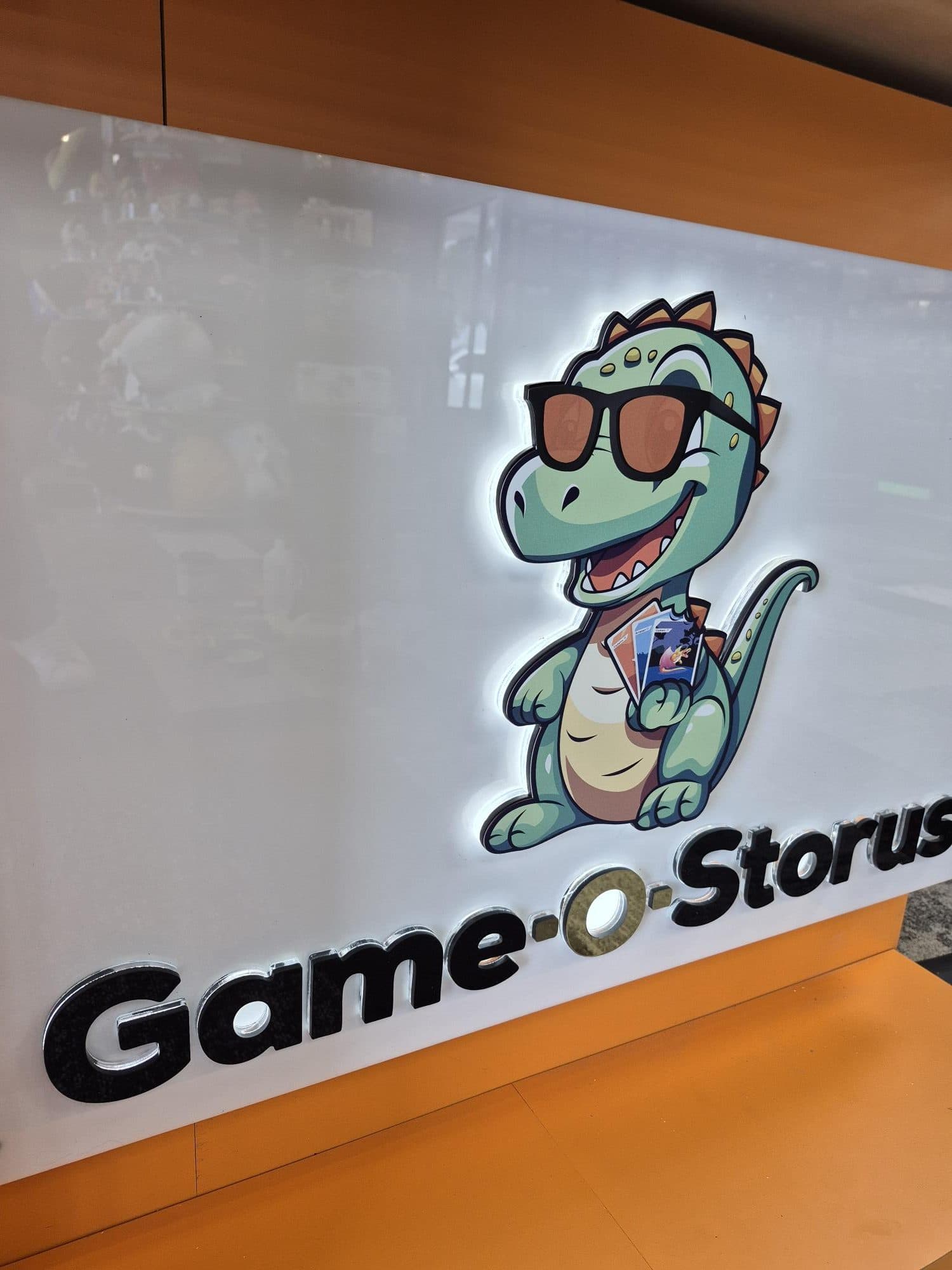 Backlit printed acrylic logo panel with a dinosaur character and dimensional letters in a Tampa store